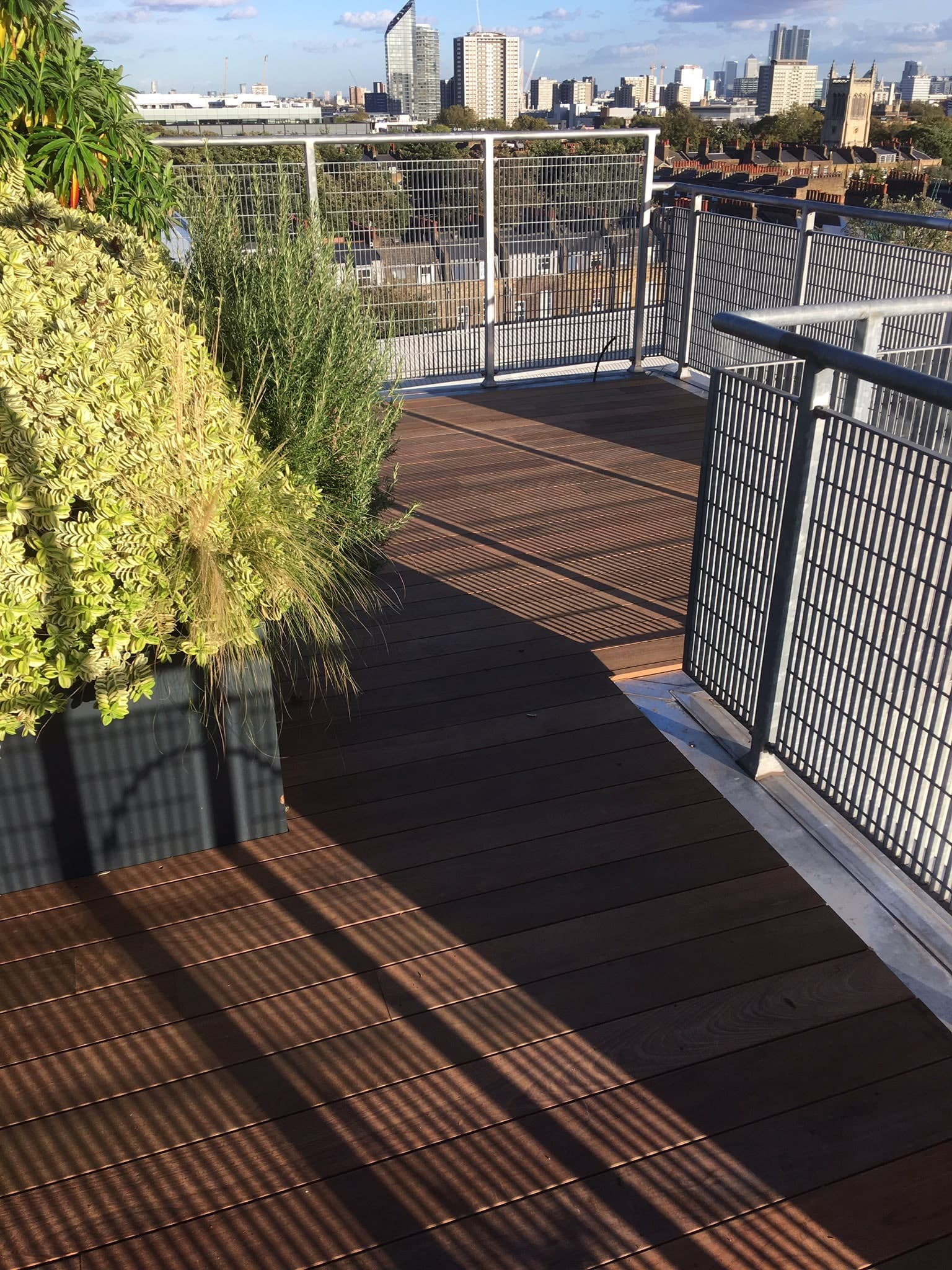 Decking terrace with planters and glass balustrade