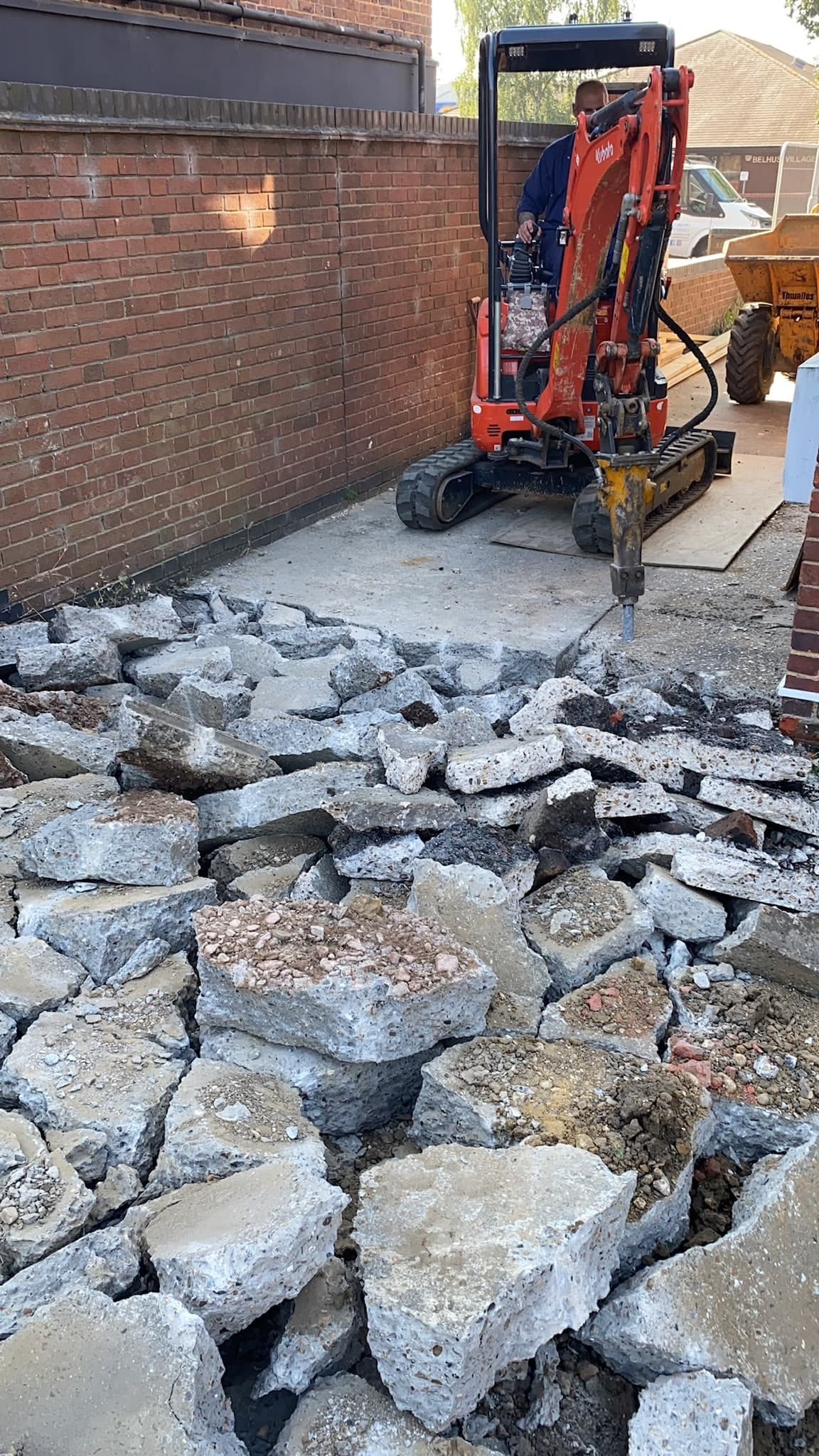 Breaking up the old concrete with a digger
