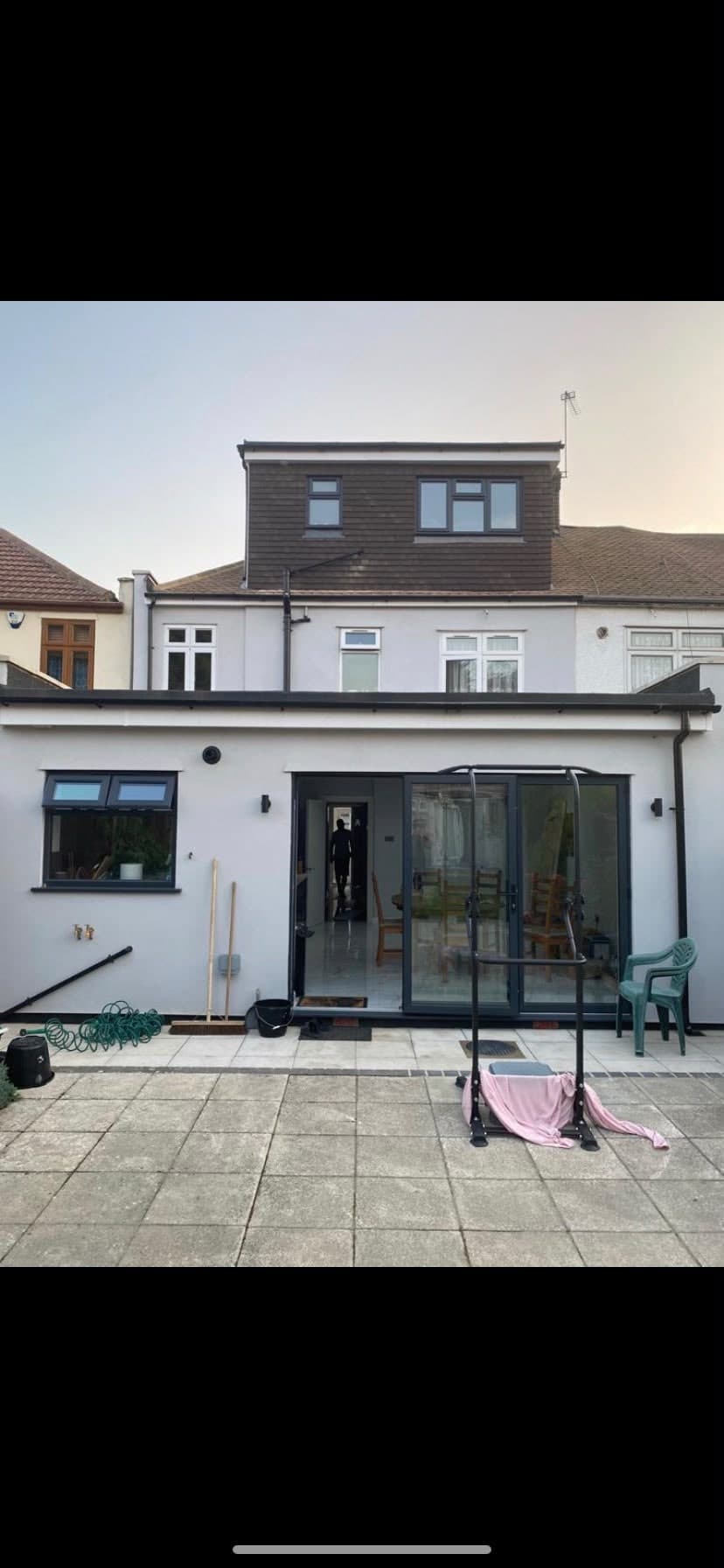 Finished rear extension in white render with bi-fold doors and a clad dormer above
