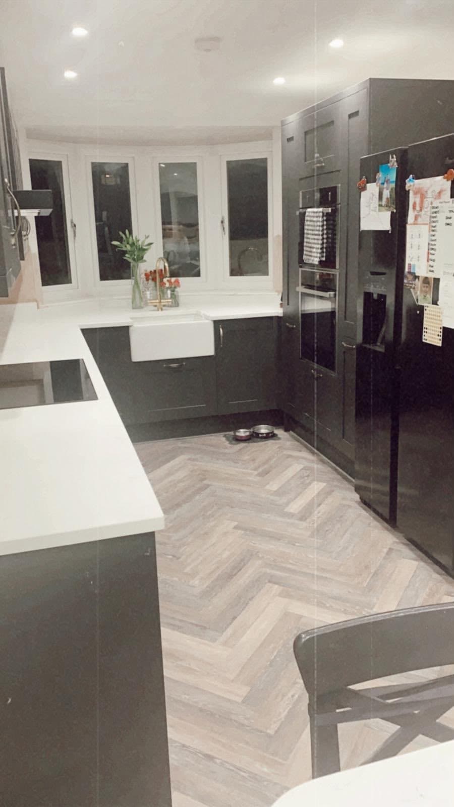 Dark gloss kitchen with white worktops and herringbone floor
