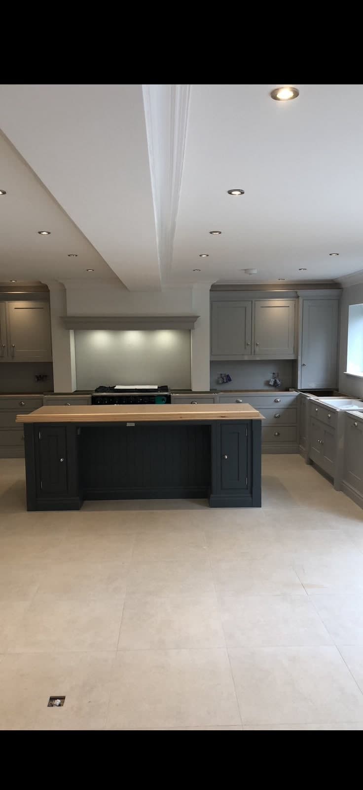 Finished grey shaker kitchen with a navy island and timber worktop