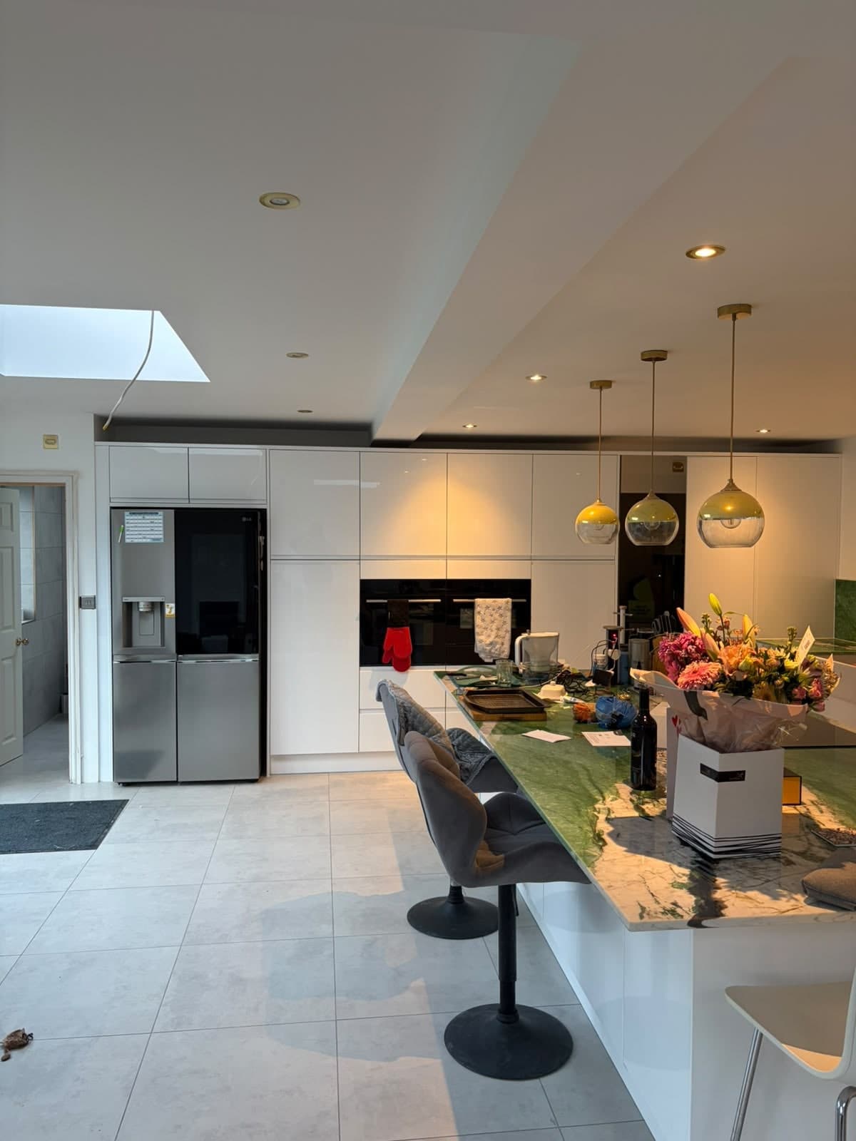 White gloss kitchen with island and gold pendant lights